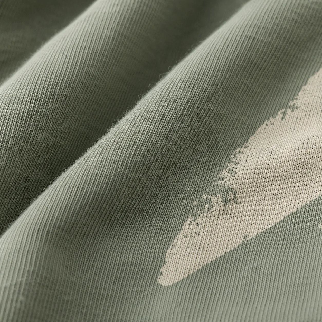 Macro close-up of sage cotton fabric and cream print